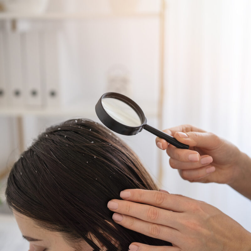 Mother checking her child’s hair for head lice under bright light